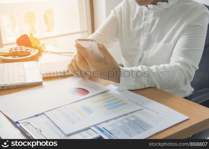 Business working woman using cellphone while working.