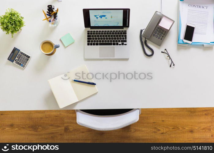 business, workplace and technology concept - laptop computer, phone and other office stuff on table top view. laptop, phone and other office stuff on table