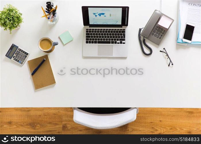 business, workplace and technology concept - laptop computer, phone and other office stuff on table top view. laptop, phone and other office stuff on table
