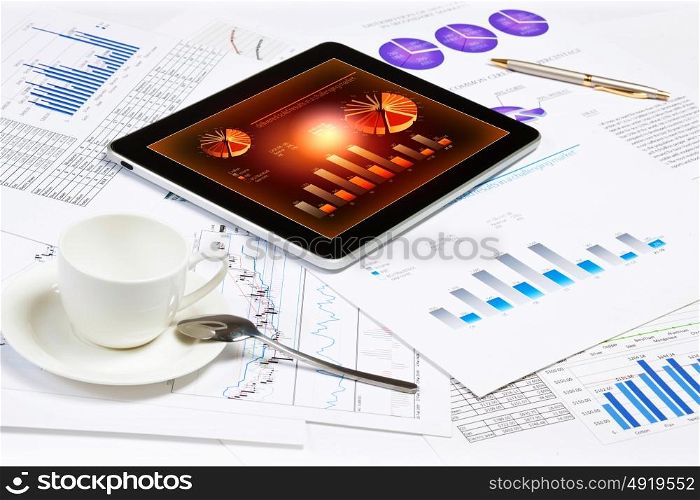 Business workplace. Image of cup of coffee and ipad laying on business documents
