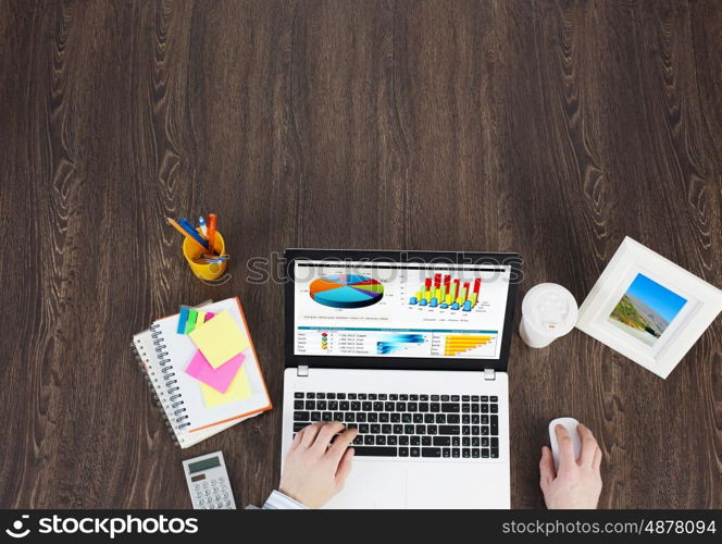 Business workplace with business stuff . Top view of business workplace and businessman hands writing in notepad