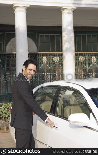 Businessman about to open car door , INDIA , DELHI