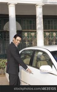 Businessman about to open car door , INDIA , DELHI