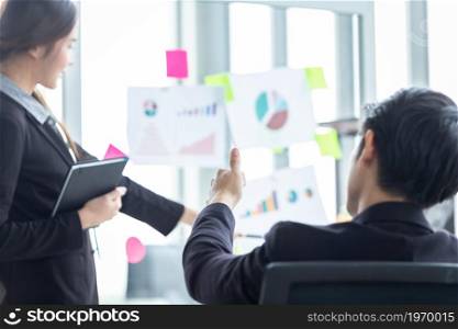 businessman Abstract blur with focus show showing thumbs up to Young asian female coach or speaker make flip chart presentation partners presenting new project ideas successful business plan in office