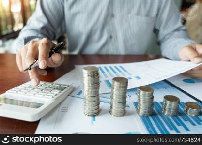 Businessman accountant Calculating on data documents And pile Stack Of coins, the savings money investment. financial Budget planning concept.