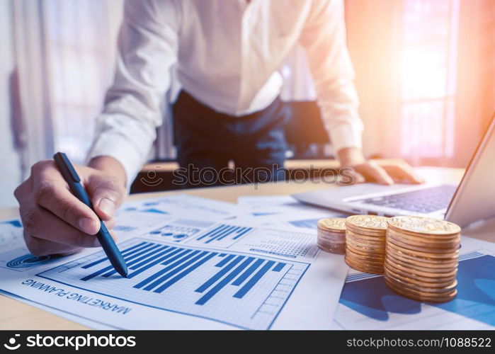 Businessman accountant or financial expert analyze business report graph and finance chart at corporate office. Concept of finance economy, banking business and stock market research.