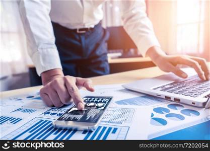 Businessman accountant or financial expert analyze business report graph and finance chart at corporate office. Concept of finance economy, banking business and stock market research.