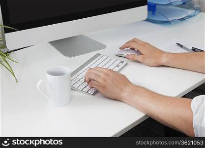 Businessman&acute;s hands using computer at desk