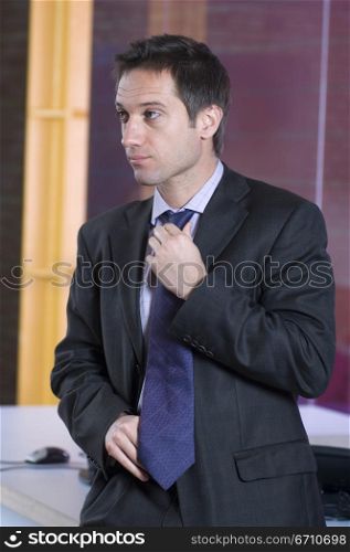Businessman adjusting his tie in an office