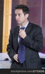 Businessman adjusting his tie in an office