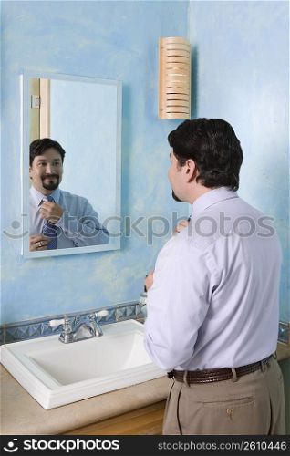 Businessman adjusting his tie in the bathroom