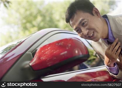 Businessman Adjusting Tie in Car Mirror