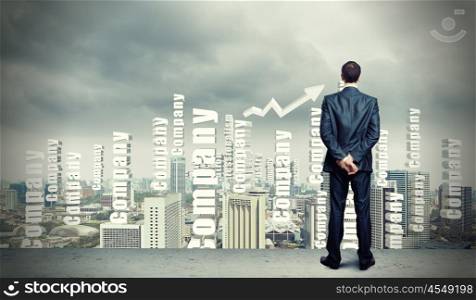 Businessman against cityscape. Successful young businessman standing against modern cityscape