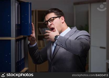 Businessman almost falling asleep working late hours in the office. Businessman almost falling asleep working late hours in the offi
