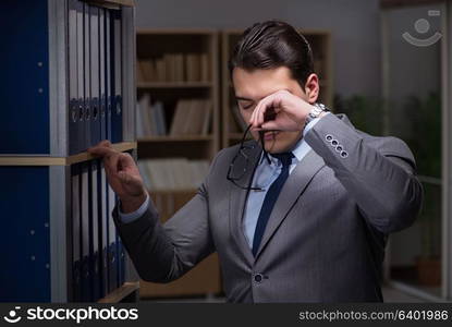 Businessman almost falling asleep working late hours in the office. Businessman almost falling asleep working late hours in the offi