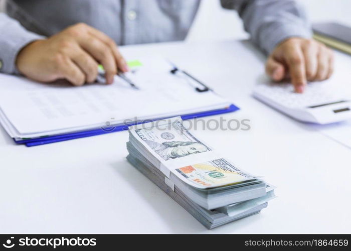 Businessman analyzing investment charts and pressing calculator buttons over documents. Accounting Concept