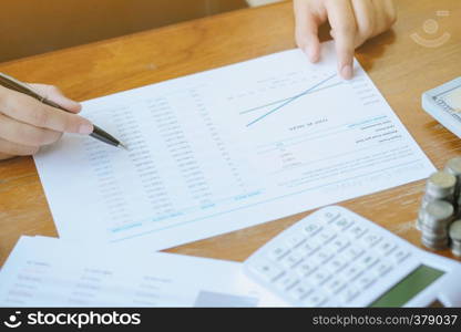 Businessman analyzing investment charts and pressing calculator buttons over documents. Accounting Concept