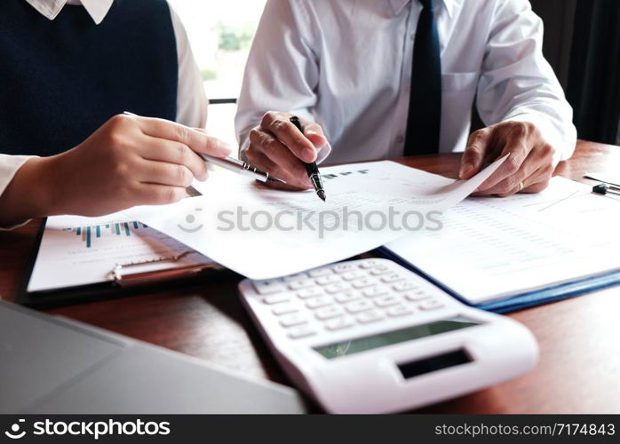 Businessman analyzing investment charts and pressing calculator buttons over documents. Accounting Concept