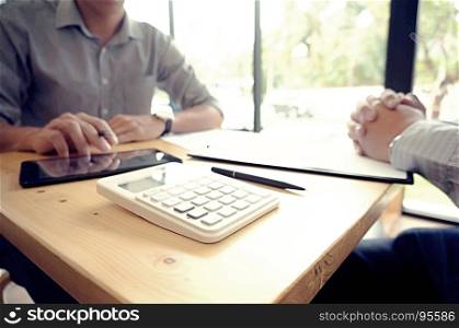 Businessman analyzing investment charts and pressing calculator buttons over documents. Accounting Concept