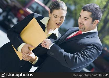 Businessman and a businesswoman checking the time in a wristwatch