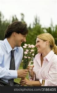 Businessman and a businesswoman holding a bunch of flowers looking at each other