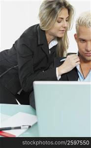 Businessman and a businesswoman in front of a laptop