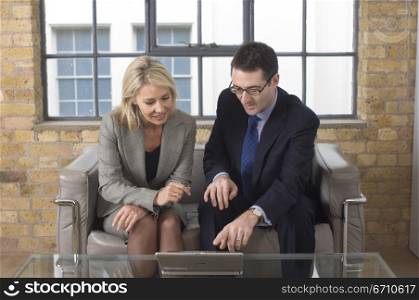 Businessman and a businesswoman looking at a laptop