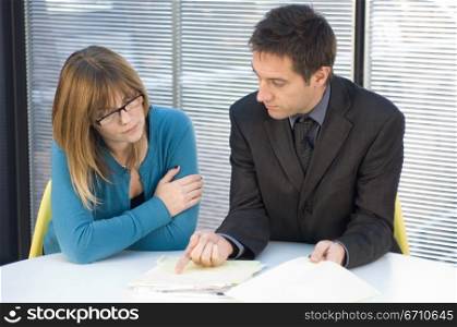 Businessman and a businesswoman sitting at a desk