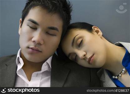 Businessman and a businesswoman sleeping at an airport
