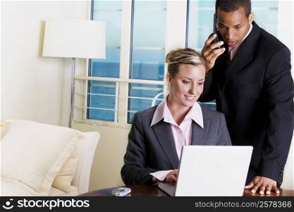 Businessman and a businesswoman using a laptop