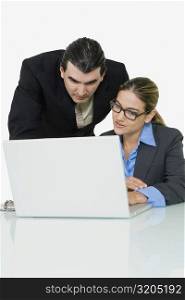 Businessman and a businesswoman using a laptop