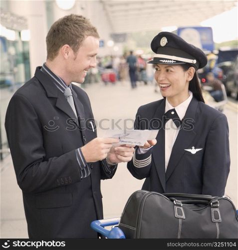 Businessman and a female pilot looking at each other and smiling