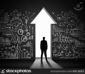Businessman and business plan. Silhouette of businessman against black wall. Business direction