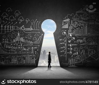 Businessman and business plan. Silhouette of businessman against black wall with key hole