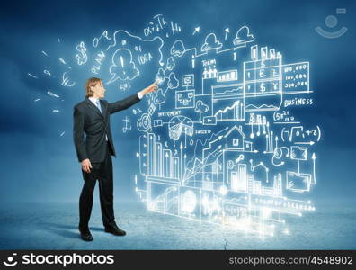 Businessman and business sketch. Image of young businessman standing against business sketch