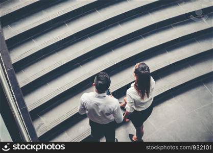 Businessman and Business woman go up the stairs Success concept