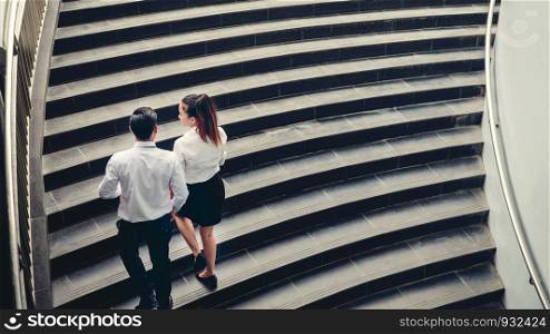 Businessman and Business woman go up the stairs Success concept