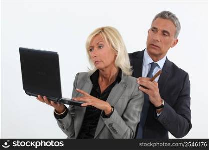 businessman and businesswoman analyzing information on their laptop
