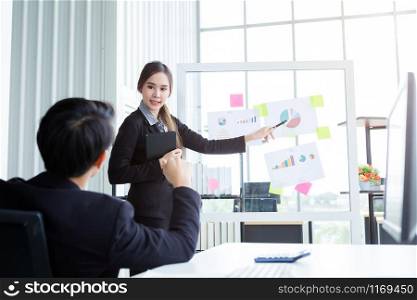businessman and businesswoman boss Two partners presenting new project ideas and the increase in received bracelets background in office,female coach presenting successful business plan