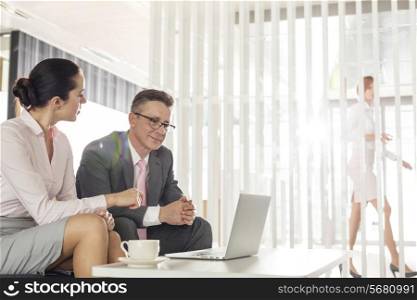 Businessman and businesswoman discussing in office