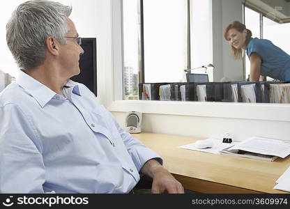 Businessman and Businesswoman in Adjoining Offices