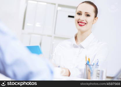 Businessman and businesswoman in office sitting at table and having conversation. Working in partnership