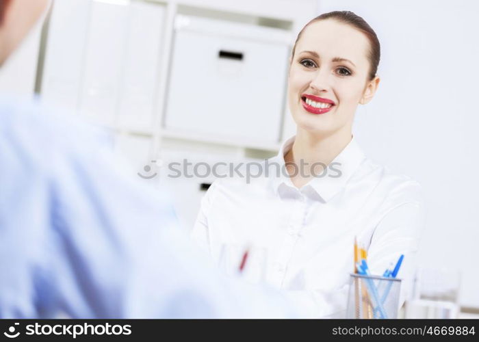 Businessman and businesswoman in office sitting at table and having conversation. Working in partnership