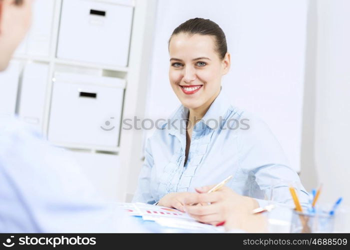 Businessman and businesswoman in office sitting at table and having conversation. Working in partnership