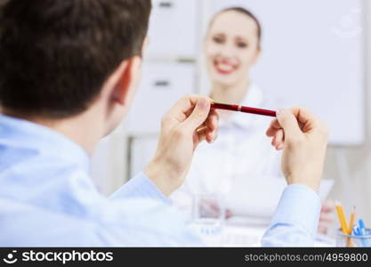 Businessman and businesswoman in office sitting at table and having conversation. Working in partnership