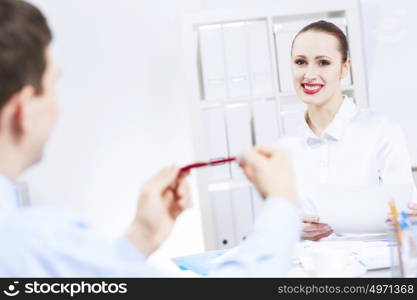 Businessman and businesswoman in office sitting at table and having conversation. Working in partnership