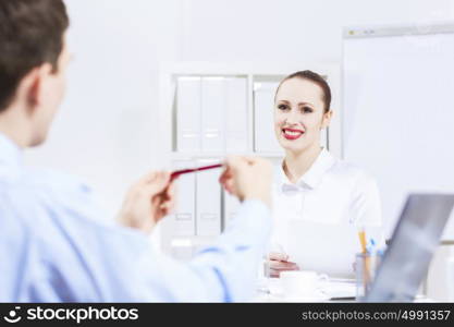 Businessman and businesswoman in office sitting at table and having conversation. Working in partnership