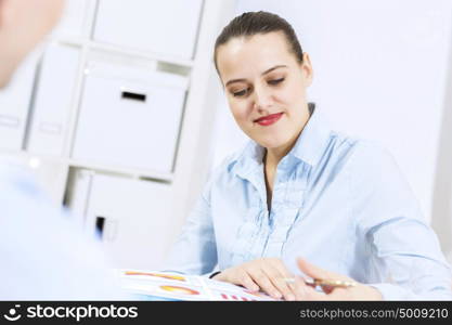 Businessman and businesswoman in office sitting at table and having conversation. Working in partnership