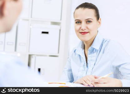 Businessman and businesswoman in office sitting at table and having conversation. Working in partnership