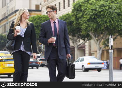 Businessman And Businesswoman In Street With Takeaway Coffee